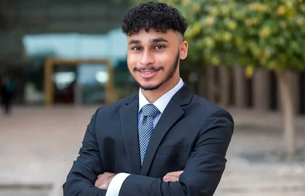 Male student in a suit smiling at the camera